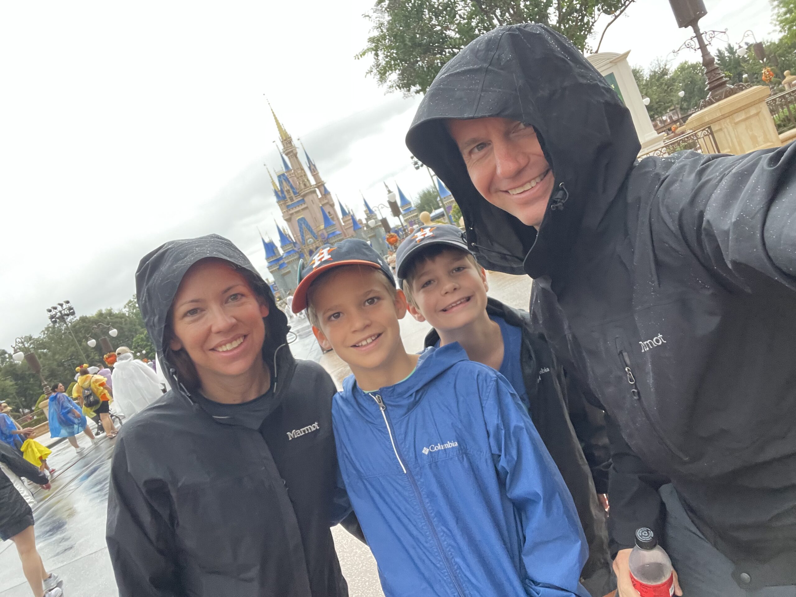 Dr. Brownfield and Family Standing in the rain at the magic kingdom