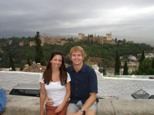 man in a blue shirt and gray shorts with woman in a white t shirt and orange shorts sitting in granada spain